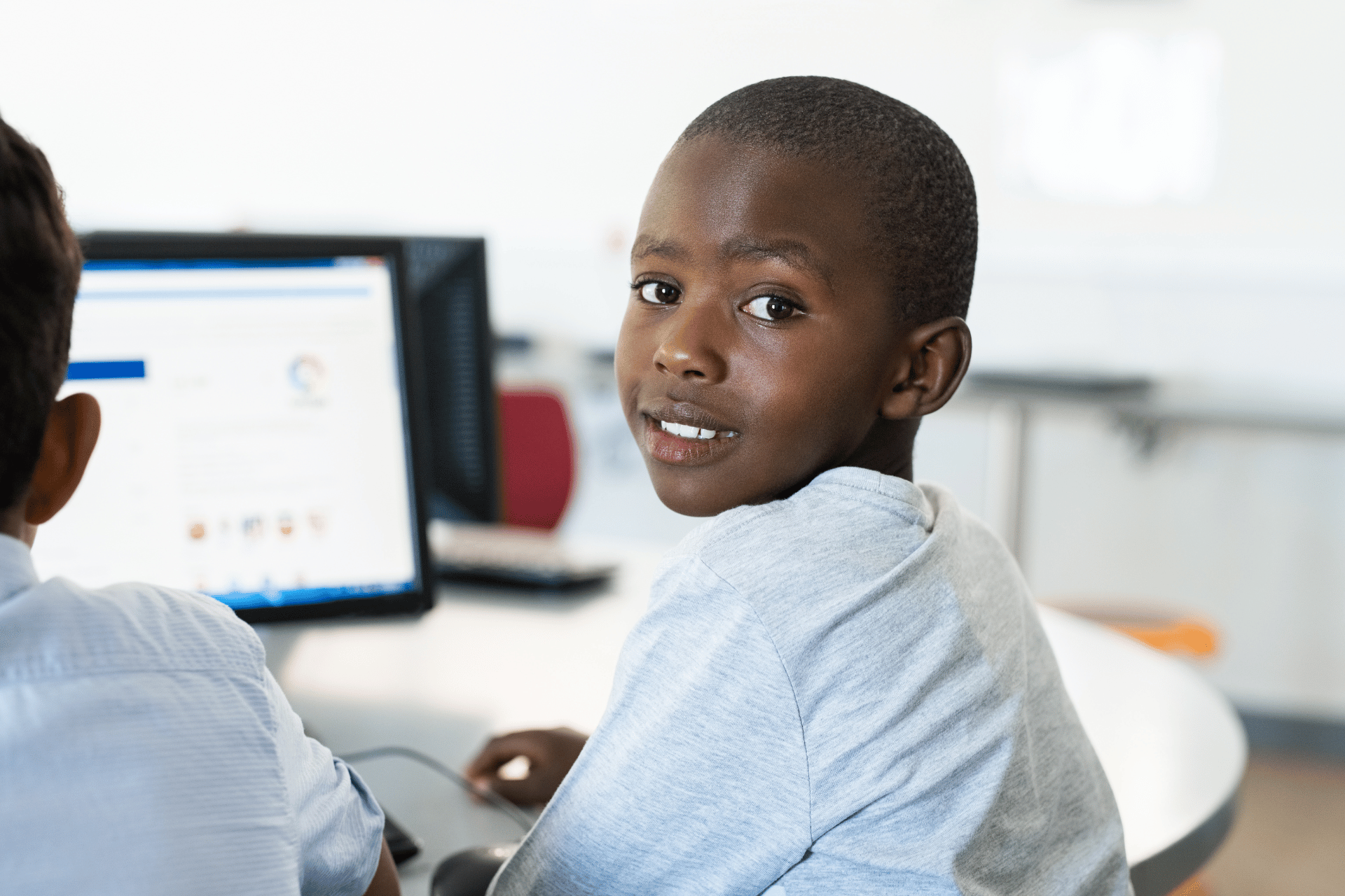 black kids , in front of the computer screen