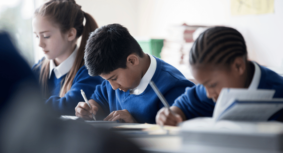 kids in the classroom writing on their exercise books