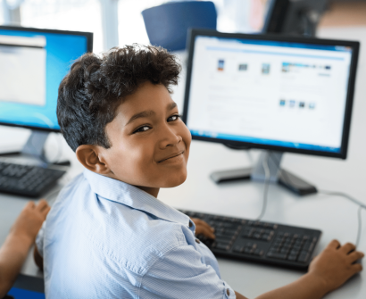 kid using a computer screen and keyboard