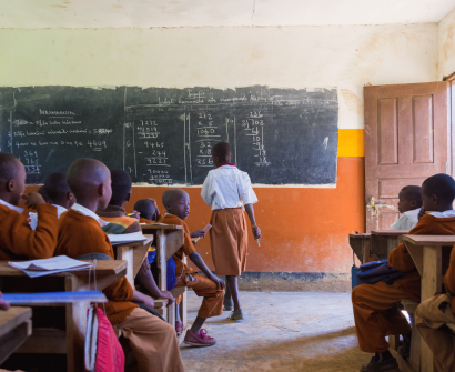 learners overflowing in the classroom , chalk board , benches